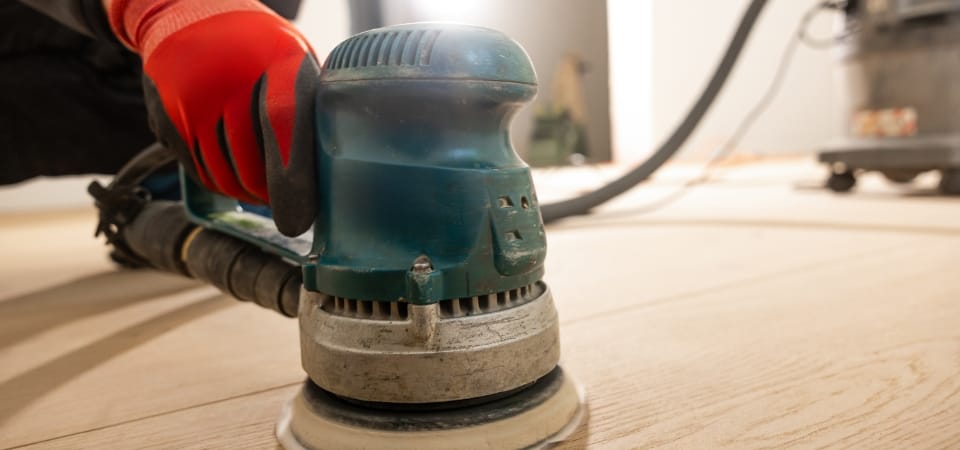 Schleifmaschine auf einem Holzboden