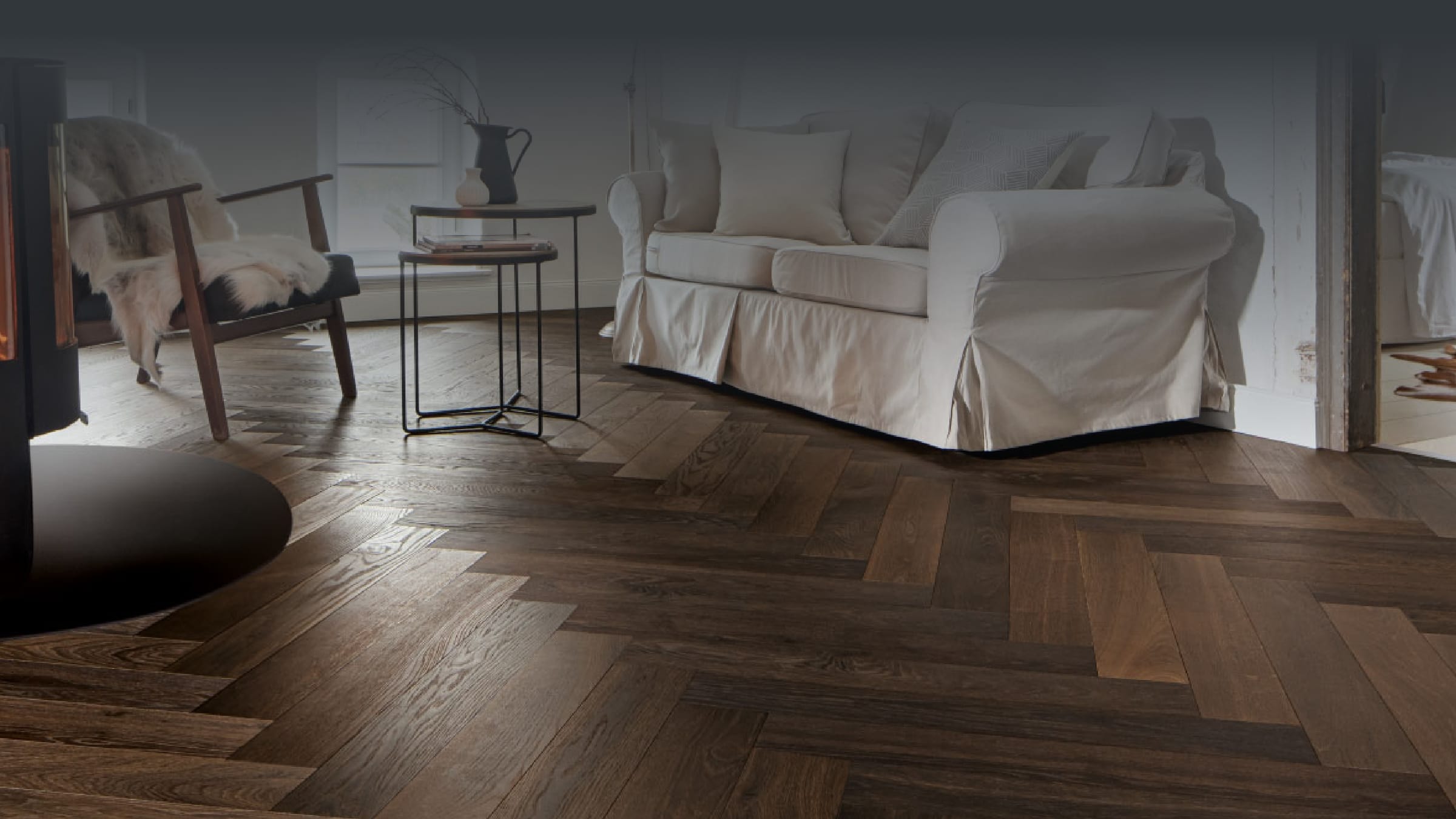 Wohnzimmer mit Holzdielenboden, Kamin und heller Sitzgruppe